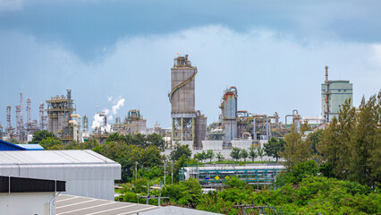 A large chemical powder storage silo located in an industrial chemical plant under a bright blue sky,