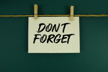 Don&rsquo;t Forget text written on paper card with rope and wooden clip hanging