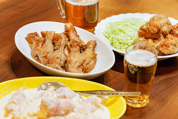 鶏肉料理とビールの賑やかな晩酌の食卓