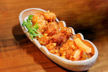 和食器に盛り付けられた鶏肉の甘酢あんかけ風料理