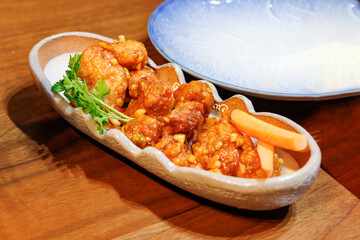 和食器に盛り付けられた鶏肉の甘酢あんかけ風料理