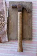 Wooden handled claw hammer sitting a small piece of wood