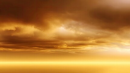 Obraz premium Dramatic Golden Sunset Over Calm Water Reflects Warm Tones in a Serene Atmospheric Landscape Filled with Clouds and Soft Lighting Effects