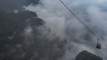 High-altitude cable car. Funicular cabins on cables over a precipice. Mountains in fog and clouds. China. Zhangjiajie. Tianmen Mountain © Вера 