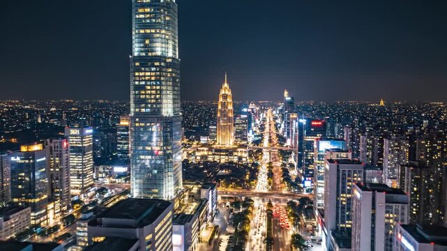 Panoramic nighttime view of modern city with illuminated skyscrapers and traffic