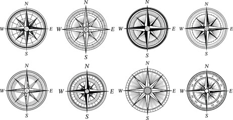Black and white vector illustration of vintage compass rose designs with cardinal directions, ornate pointers, concentric circles, and navigation symbols