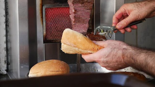 Chef Slicing Doner Kebab Meat into Fresh Bread
