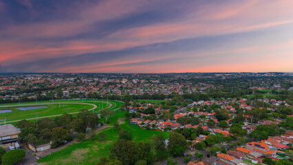 Fototapeta premium Panoramic Aerial Drone view of Inner Western Suburbs of Sydney housing, roof tops, the streets and the parks, the roads and trees of Ashbury Ashfield Burwood Summer Hill Canterbury and Campsie in Sydn