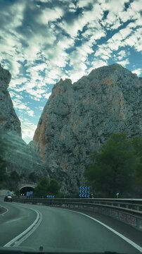 Calpe, Valencia, Spain. October 20, 2025. Vertical video shot from a car. View of a high mountain near the road. Rock near the road. Beautiful landscape. road in mountains