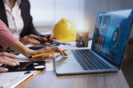 Business people working on construction project with virtual interface of smart building management system. Architect and engineer analyzing energy efficiency, home automation icons, and real concept.