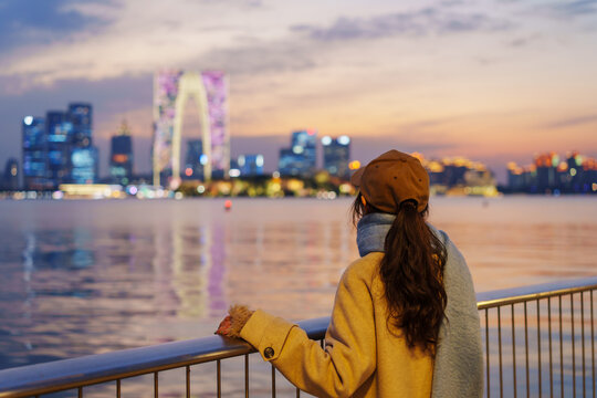 Young female tourist enjoying the night view of the landmark building at Jinji Lake in Suzhou, China