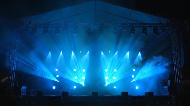 Live concert stage illuminated with blue lights and fog creating atmospheric energy.