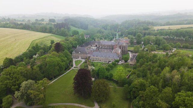 valley placement intricate stonework define abbey presence slate roofs tapered spire rolling hills recede val dieu belgium val-dieu architectural 