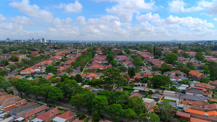 Obraz premium Panoramic Aerial Drone view of Inner Western Suburbs of Sydney housing, roof tops, the streets and the parks, the roads and trees of Ashbury Ashfield Burwood Summer Hill Canterbury and Campsie in Sydn