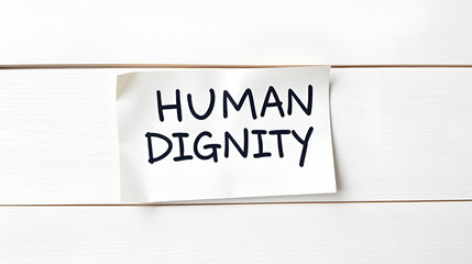 HUMAN DIGNITY - words on a note sheet on a wooden light background