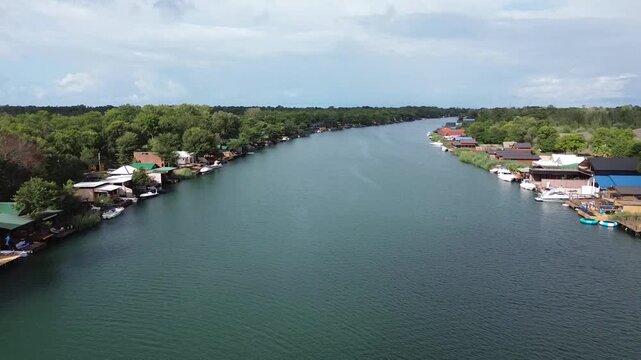 Cinematic aerial perspective of Ada Bojana river bank with rustic wooden cabins in Montenegro
