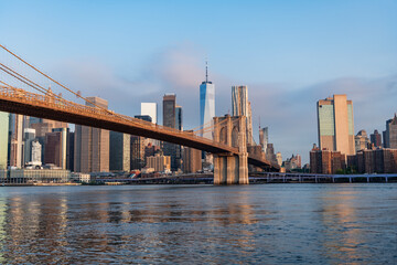 Fototapeta premium Brooklyn bridge of New York city. Brooklyn landmark. Urban panorama. Manhattan cityscape with skyscraper architecture. Brooklyn bridge to Manhattan. Urban architecture of New York city