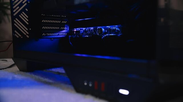 Motherboard lighting smoothly changes colors inside a desktop computer case, creating a vivid visual effect in a dark environment
