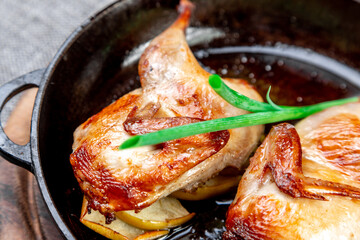 Fried Quail on Apples, Served in a Cast Iron Skillet. Close-up