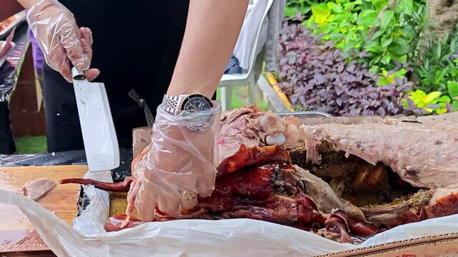 Chef Slicing Traditional Balinese Roasted Suckling Pig (Babi Guling) for Serving