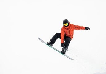 Snowboarder performs aerial trick during winter sports activity white background