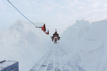 a large happy dog runs along the wooden floor between snow drifts to its owner on a frosty day