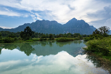 Vang Vieng, Laos: Dramatic reflection on the Nam Ou river of Vang Vieng famous  karst landscape during rainy season in Laos