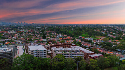 Fototapeta premium Panoramic Aerial Drone view of Inner Western Suburbs of Sydney housing, roof tops, the streets and the parks, the roads and trees of Ashbury Ashfield Burwood Summer Hill Canterbury and Campsie in Sydn