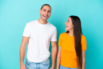 Fototapeta premium Young caucasian couple isolated on blue background with surprise facial expression