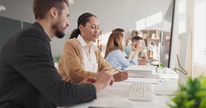 Students and instructor coding at computer classroom. Adults join training with collaboration and teamwork, sharing ideas and solving tasks at computers. Concept of collaborative tech learning.