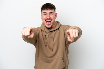 Fototapeta premium Young caucasian handsome man isolated on white background surprised and pointing front