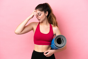 Young sport woman going to yoga classes while holding a mat laughing