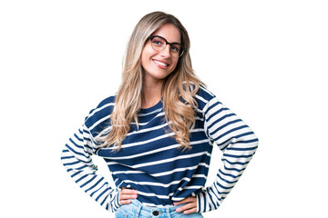 Young Uruguayan woman over isolated background posing with arms at hip and smiling