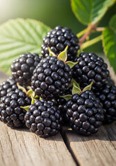 A vibrant pile of fresh blackberries on a rustic wooden surface with green leaves in the background