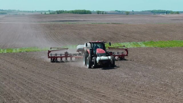 Tractor working in field with agricultural equipment on sunny day outdoors