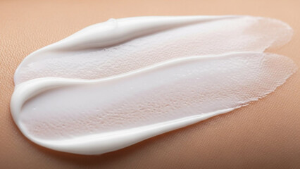 Close up of a white cosmetic cream swatch on skin.