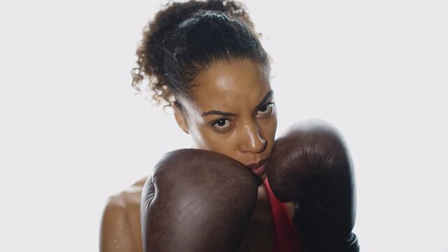 Cinematic video of a fit young woman training in the gym with weights and aerobic exercises. Boxer Woman doing shadow boxing workoutin the fitness club.	