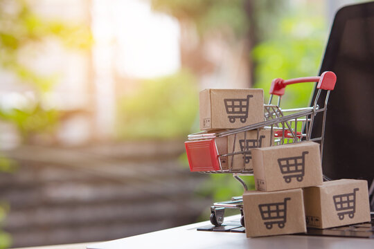 Shopping online. cardboard box with a shopping cart logo in a trolley on laptop keyboard. Shopping service on The online web. offers home delivery