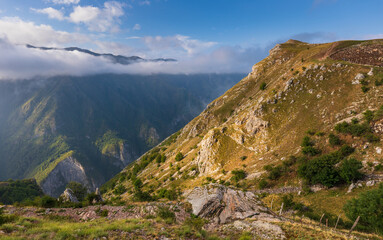 Fototapeta premium Mountain peaks with clouds surrounding valley in Bosnia and Herzegovina.
