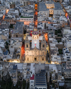 Aerial view of the illuminated Parish Church of Stella Maris standing tall against the twilight sky, Sliema, Sliema, Malta.