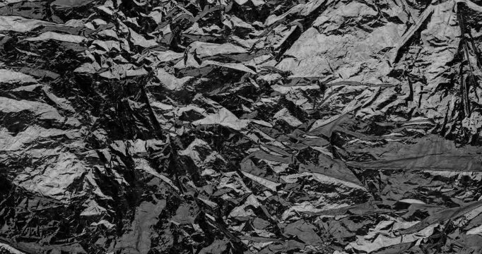Stop-Motion Crumpled Foil Texture. Rapid stop-motion animation featuring quick successive frame changes of heavily wrinkled aluminum foil surfaces.