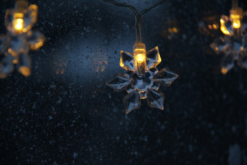 decorative snowflake light string on frosty window