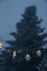 decorative snowflake light string on frosty window