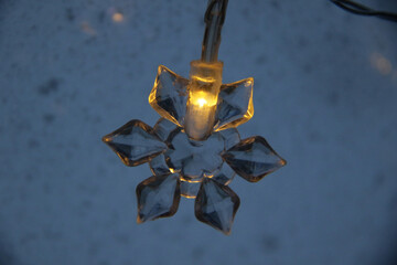 decorative snowflake light string on frosty window