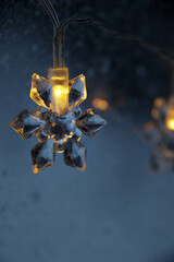 decorative snowflake light string on frosty window