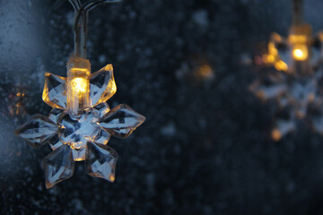 decorative snowflake light string on frosty window