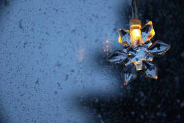 decorative snowflake light string on frosty window