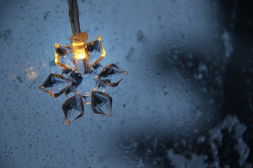 decorative snowflake light string on frosty window