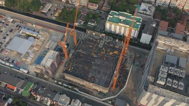High angle view showing the construction of a new large scale data center building in bangkok, with several tower cranes operating