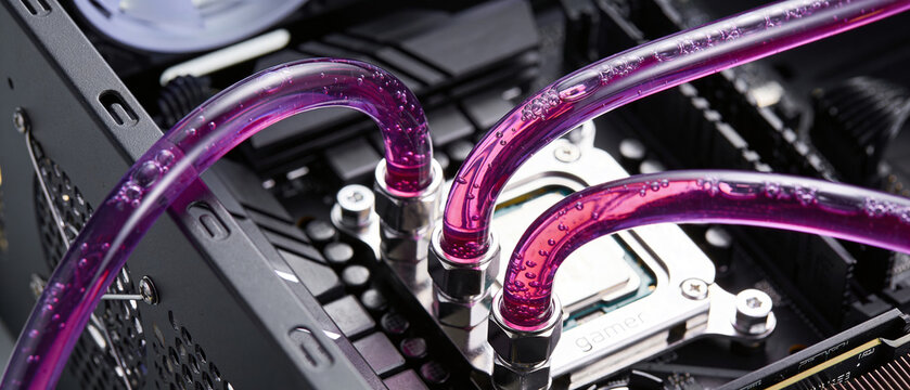 Close up of custom liquid cooling tubes for a high performance gaming computer. Modern cpu water cooler for data processing.